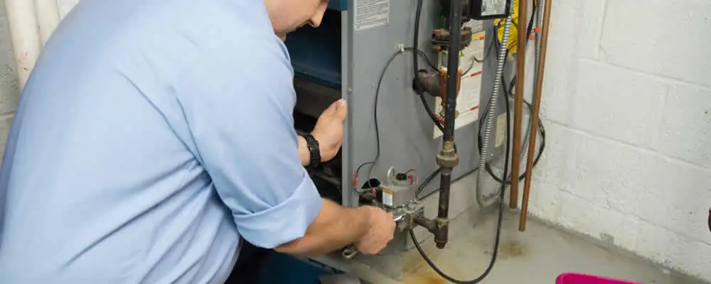 Furnace repair technician inspecting and servicing a home heating system in Green Bay, WI