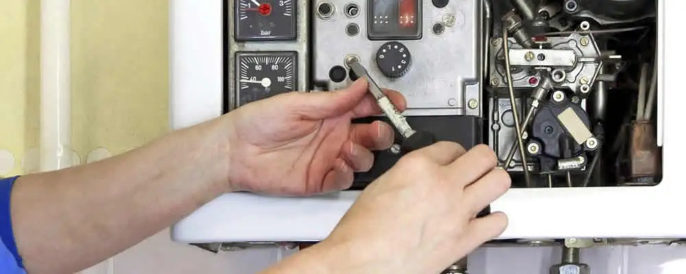 Heating repair technician adjusting boiler controls and components in Green Bay, WI