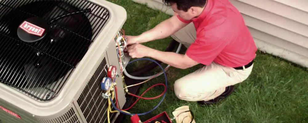 HVAC technician servicing an outdoor air conditioner unit in Green Bay, WI