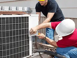 HVAC technicians repairing an outdoor AC unit on a rooftop in Green Bay, WI